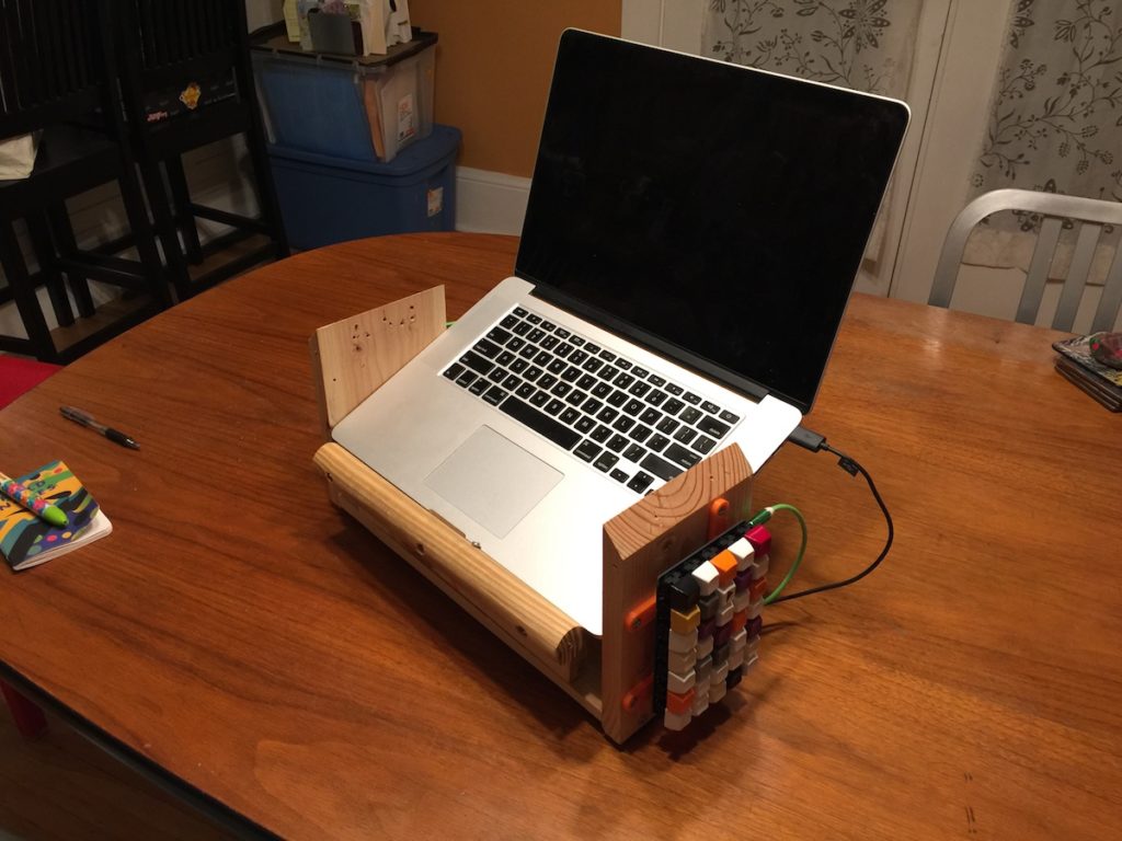 A scrap wood laptop stand with a laptop installed.